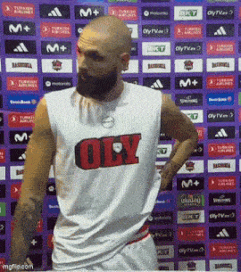 a bald man with a beard is wearing a white tank top that says oly