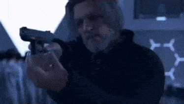 a man is holding a gun in a dark room .