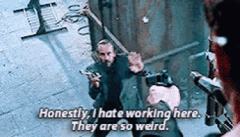 a man is holding a gun in front of another man and says `` honestly , i hate working here .