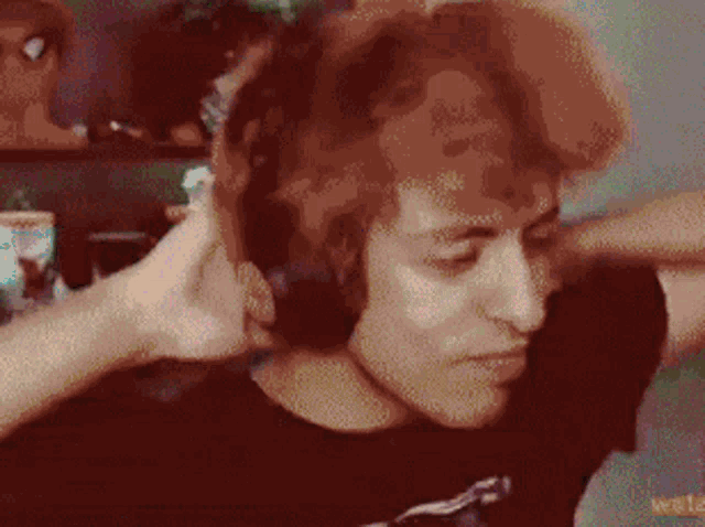 a man with red hair is wearing headphones .