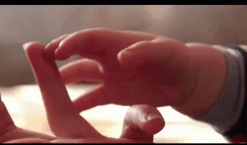 a close up of a person 's hands playing with a baby 's hand .