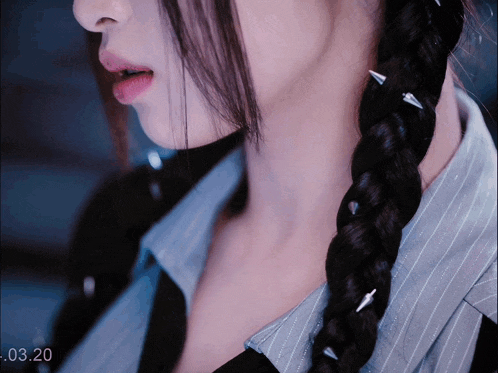 a close up of a woman 's neck and braid with a time stamp of -03-20
