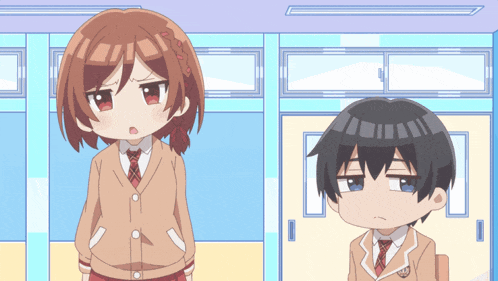 a boy and a girl standing next to each other in a classroom