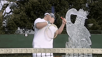 a man is holding a tennis racquet next to a statue of a bird on a tennis court