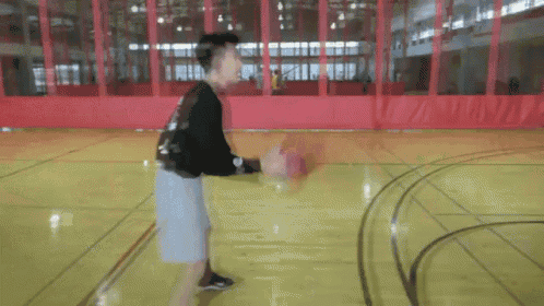 a young man is dribbling a basketball on a court .