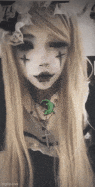 a woman with a cross on her face is wearing a necklace