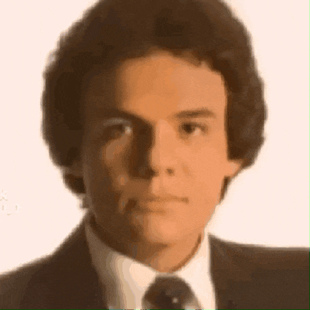 a close up of a man 's face with a suit and tie