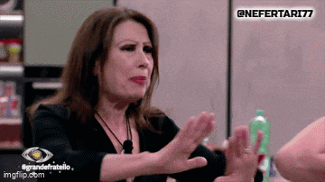 a woman in a black shirt is making a gesture with her hands