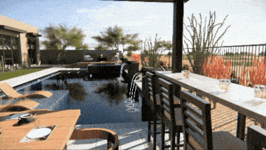 a table and chairs in front of a pool