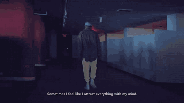 a man walking down a dark hallway with the words " sometimes i feel like i attract everything with my mind " below him