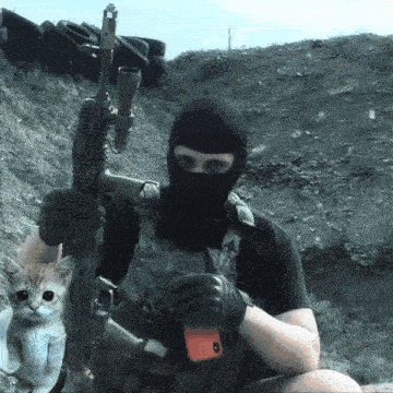 a man wearing a mask is holding a rifle and a cell phone