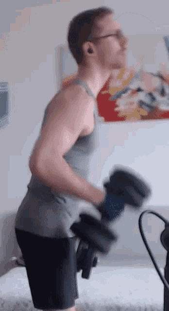 a man is lifting a dumbbell in front of a painting on a wall .