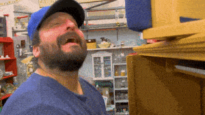 a man with a beard wearing a blue hat is crying