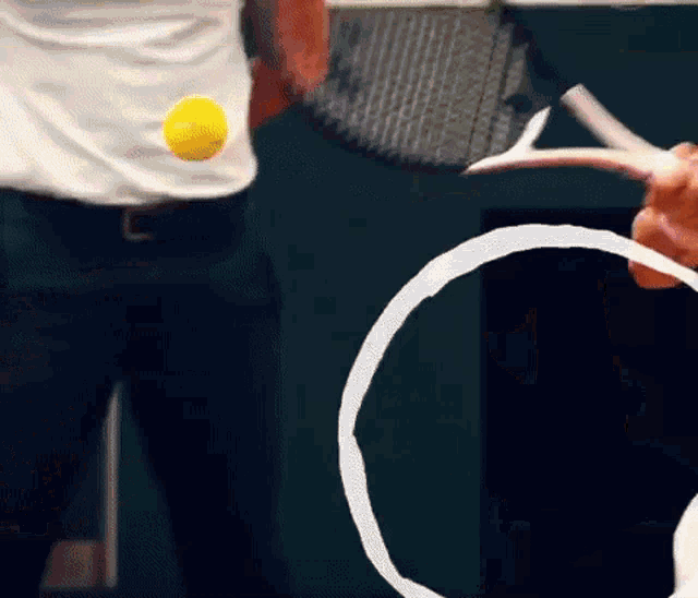 a person is holding a tennis racquet with a yellow tennis ball on their back
