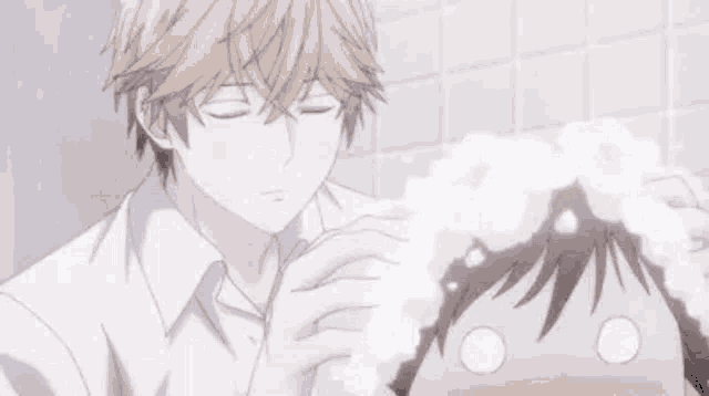 a boy is washing another boy 's hair in a bathtub .