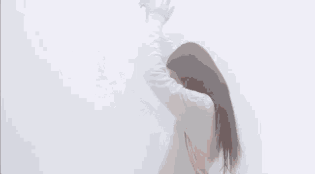 a woman is standing in the fog with her arms outstretched .