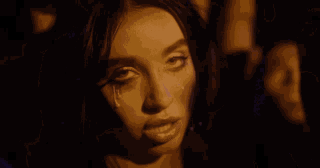 a woman with tears running down her face is surrounded by people