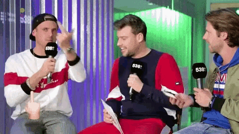 three men are sitting in front of microphones one of which has the number 638 on it