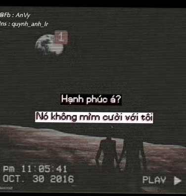 a couple of people standing next to each other in a dark room with a play button on the bottom .