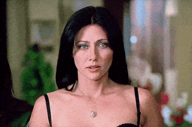 a woman wearing a bra and a necklace with a pendant on it