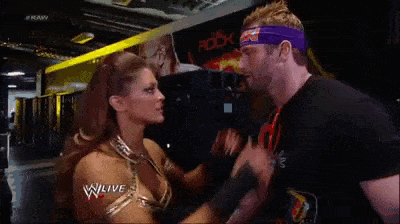 a man and a woman are kissing in front of a screen that says w live