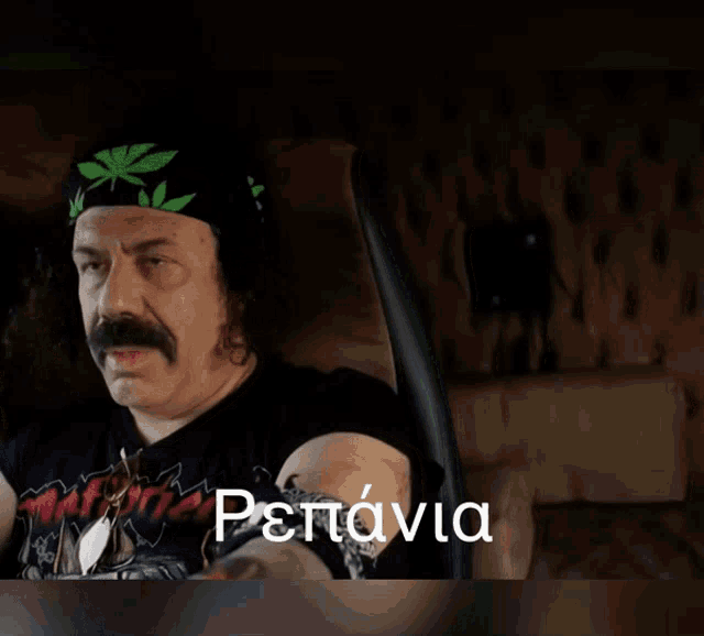 a man with a bandana on his head is sitting in a chair with the word repania on the bottom right