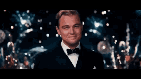 a man in a tuxedo and bow tie is smiling and looking at the camera .