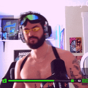a man wearing headphones and goggles stands in front of a sign that says success is a journey