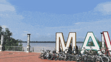 a row of bikes are parked in front of a large sign that says imai