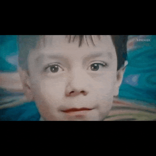 a close up of a child 's face with a blue background