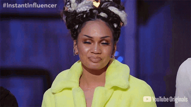 a woman is wearing a yellow coat and making a face .