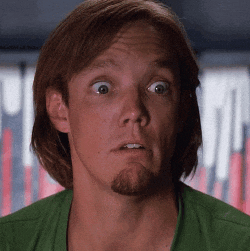 a man with long hair and a beard is wearing a green shirt