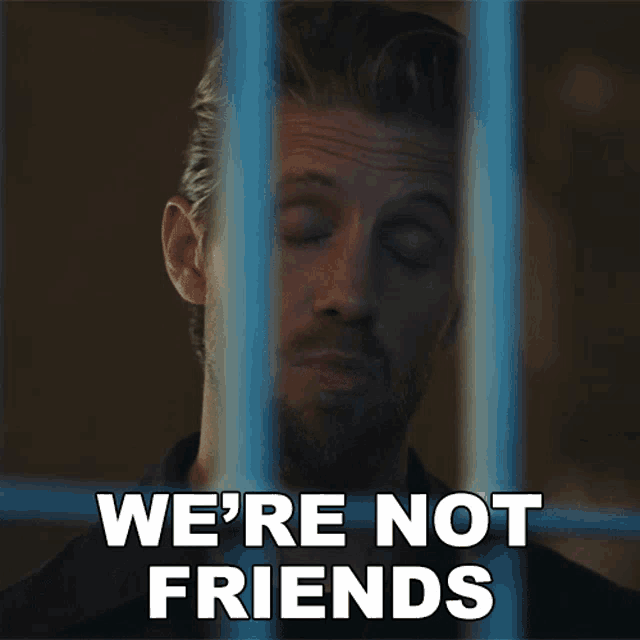 a man behind bars with the words we 're not friends behind him