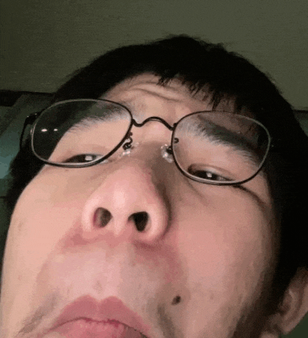 a close up of a man wearing glasses and making a face .