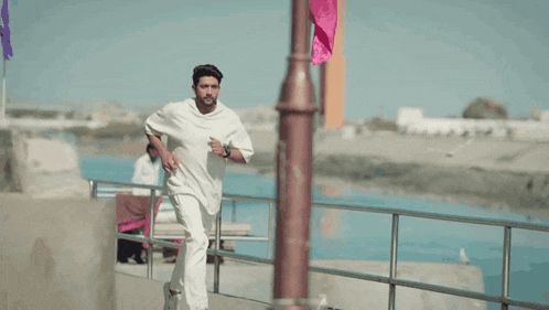 a man in a white shirt and white pants is running