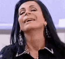 a close up of a woman 's face with her eyes closed and smiling .