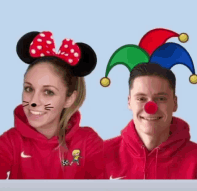 a woman wearing minnie mouse ears and a man wearing a jester 's hat