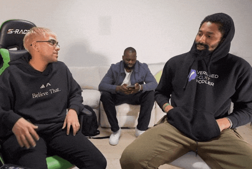 a man wearing a black hoodie that says believe that
