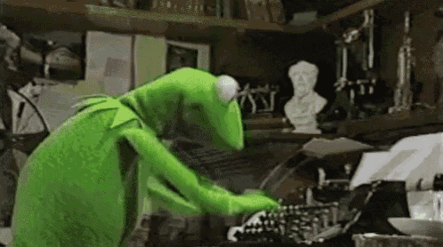 kermit the frog is using a typewriter in a messy room .