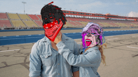 a man wearing a red bandana stands next to a woman wearing a colorful mask