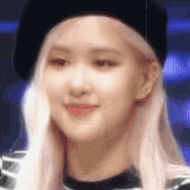 a close up of a woman 's face wearing a black beret .