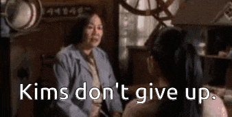 a woman is talking to another woman in a room with the words `` kims don 't give up '' written on the screen .