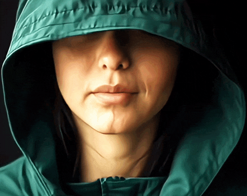 a close up of a woman wearing a green hood