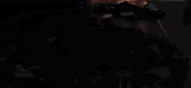 a person standing in a dark room with a piece of clothing on the floor