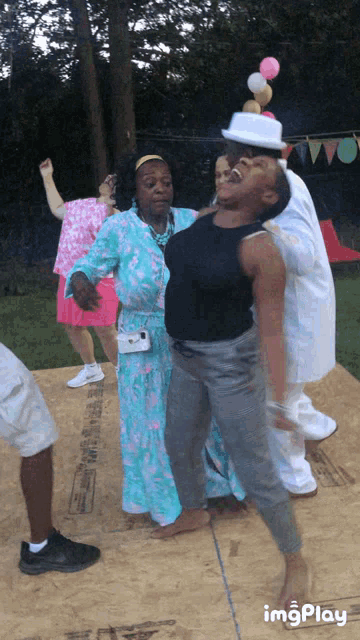 a group of people are dancing on a wooden floor with a sign that says imgplay
