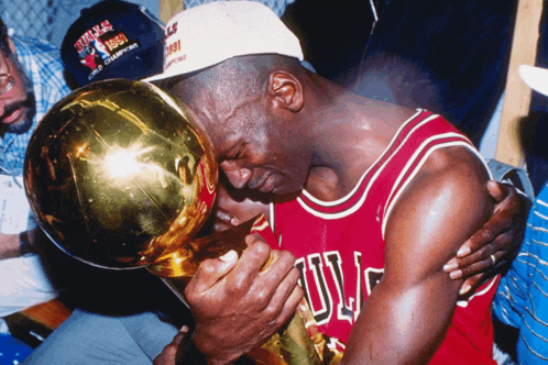a man wearing a bulls jersey holds a trophy