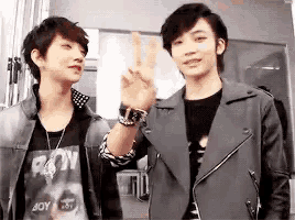 two young men are standing next to each other and one is wearing a shirt that says boy on it