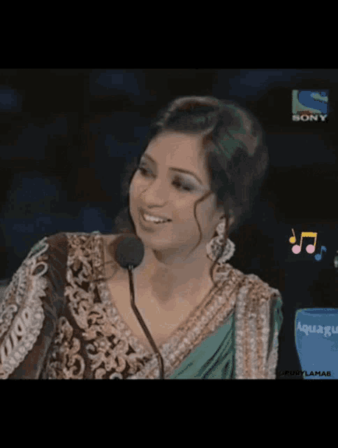 a woman is smiling in front of a sony television