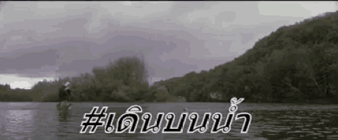 a man in a kayak is floating on a lake with mountains in the background and a # written on the bottom