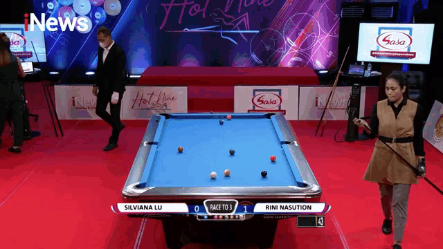 a pool table with a woman holding a cue in front of a sign that says inews